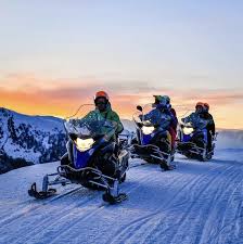 Tour guidato in motoslitta sulla neve in montagna